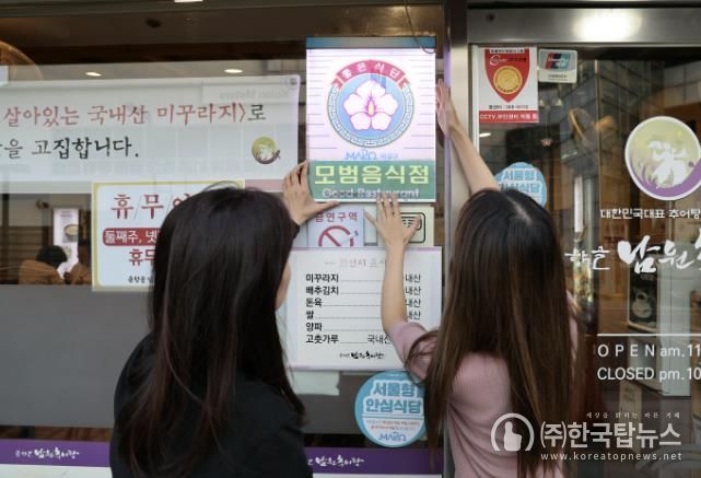 모범음식점으로 선정된 음식점에 모범음식점 표지판을 다는 모습
